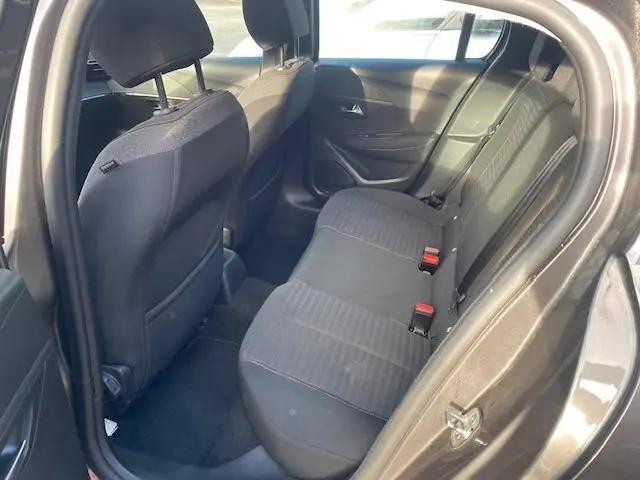 Vue intérieure côté droit sur la banquette arrière noire avec surpiqûres rouges du Peugeot 208 gris platinium 2021.