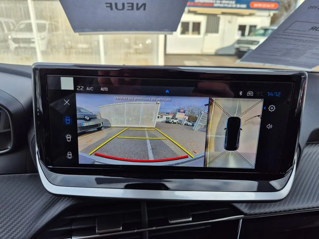 Écran tactile du cockpit numérique de la Peugeot 208 Hybrid blanc, affichant la caméra de recul et vue 360° intérieure.
