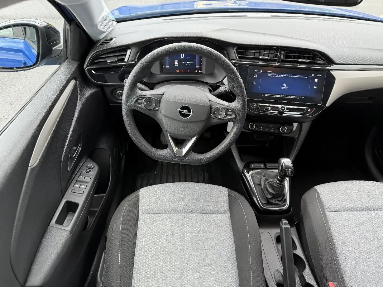 Vue intérieure centrée sur le volant Opel Corsa 2025, avec tableau de bord numérique et levier de vitesse manuel.