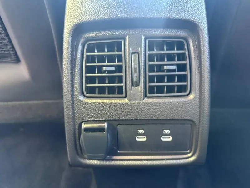 Vue rapprochée des aérateurs arrière et des ports USB de recharge dans l'habitacle noir du Renault Captur 2025.