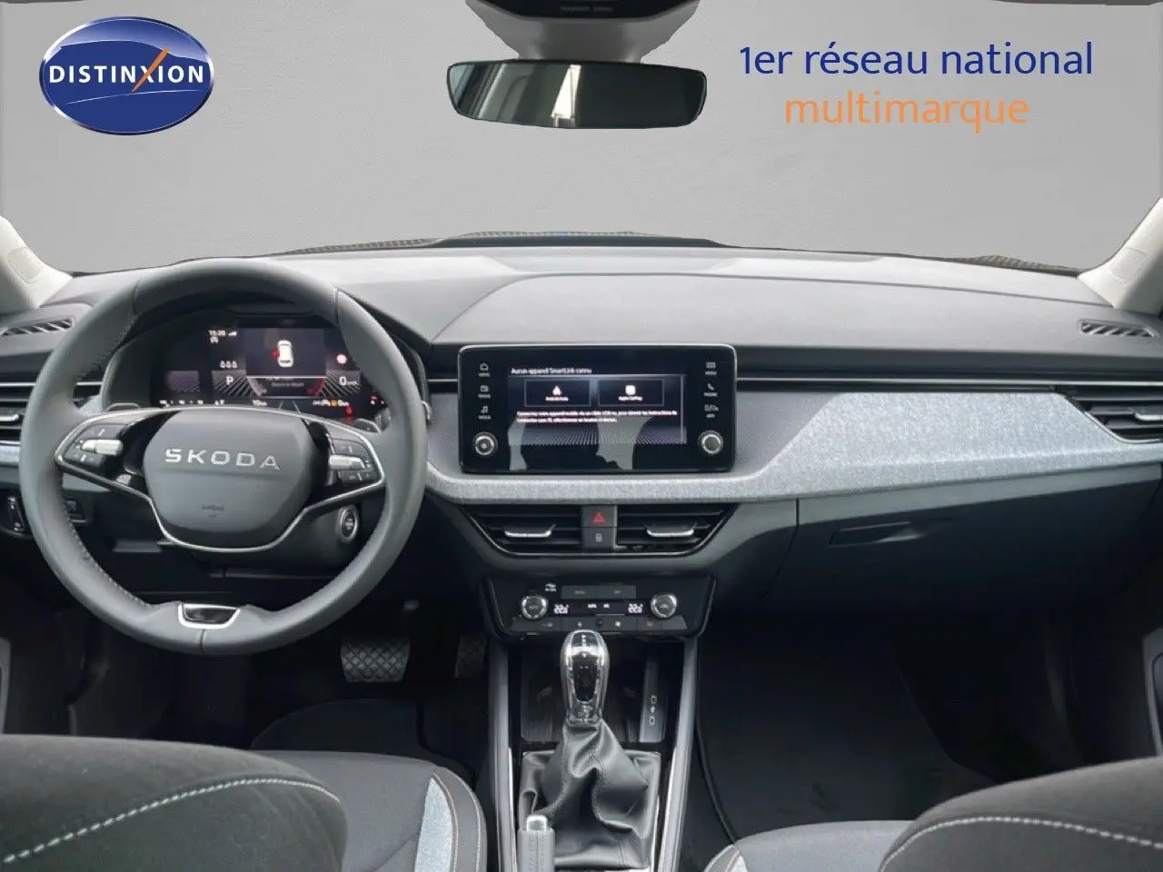 Vue intérieure frontale du tableau de bord et volant noir du Skoda Kamiq 2025 avec écran tactile central et finition grise.