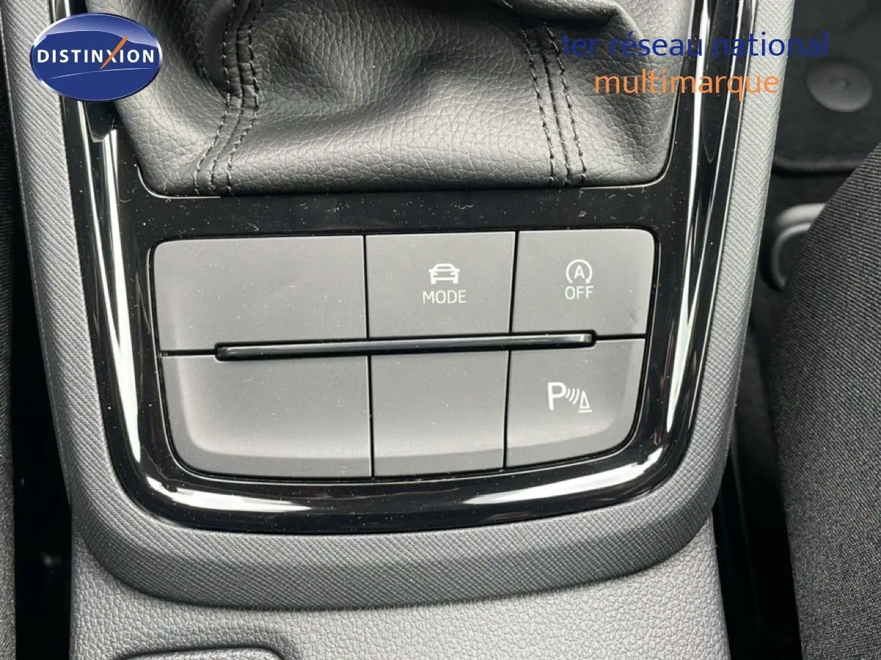 Gros plan sur les commandes de mode de conduite et assistance au stationnement du Skoda Kamiq noir magique métal.