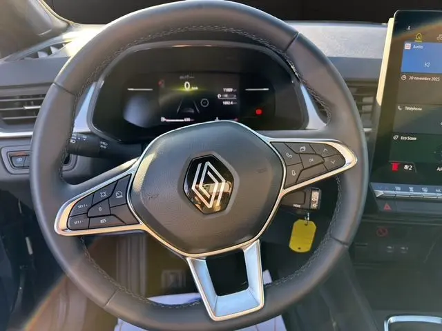 Vue rapprochée du volant noir de la Renault Captur 2024 avec commandes intégrées et tableau de bord numérique.