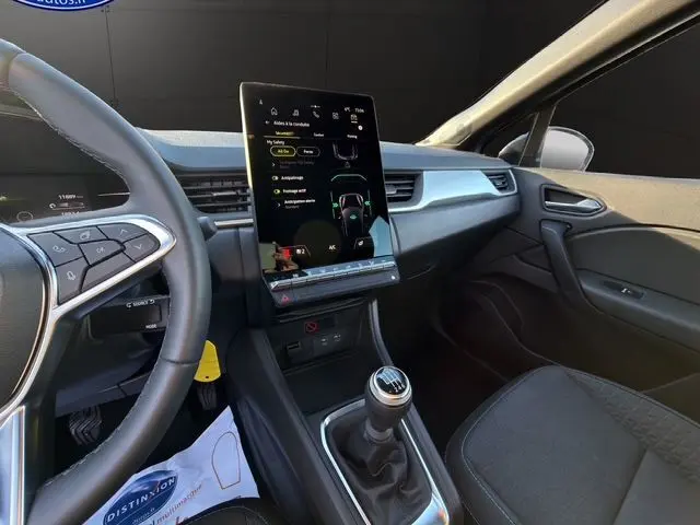 Vue intérieure côté conducteur du Renault Captur TCe 90 Evolution 2024, avec écran tactile vertical et boîte manuelle.