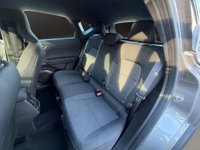 Vue intérieure côté droit montrant la banquette arrière en tissu gris du Renault Captur TCe 90 Evolution 2024.
