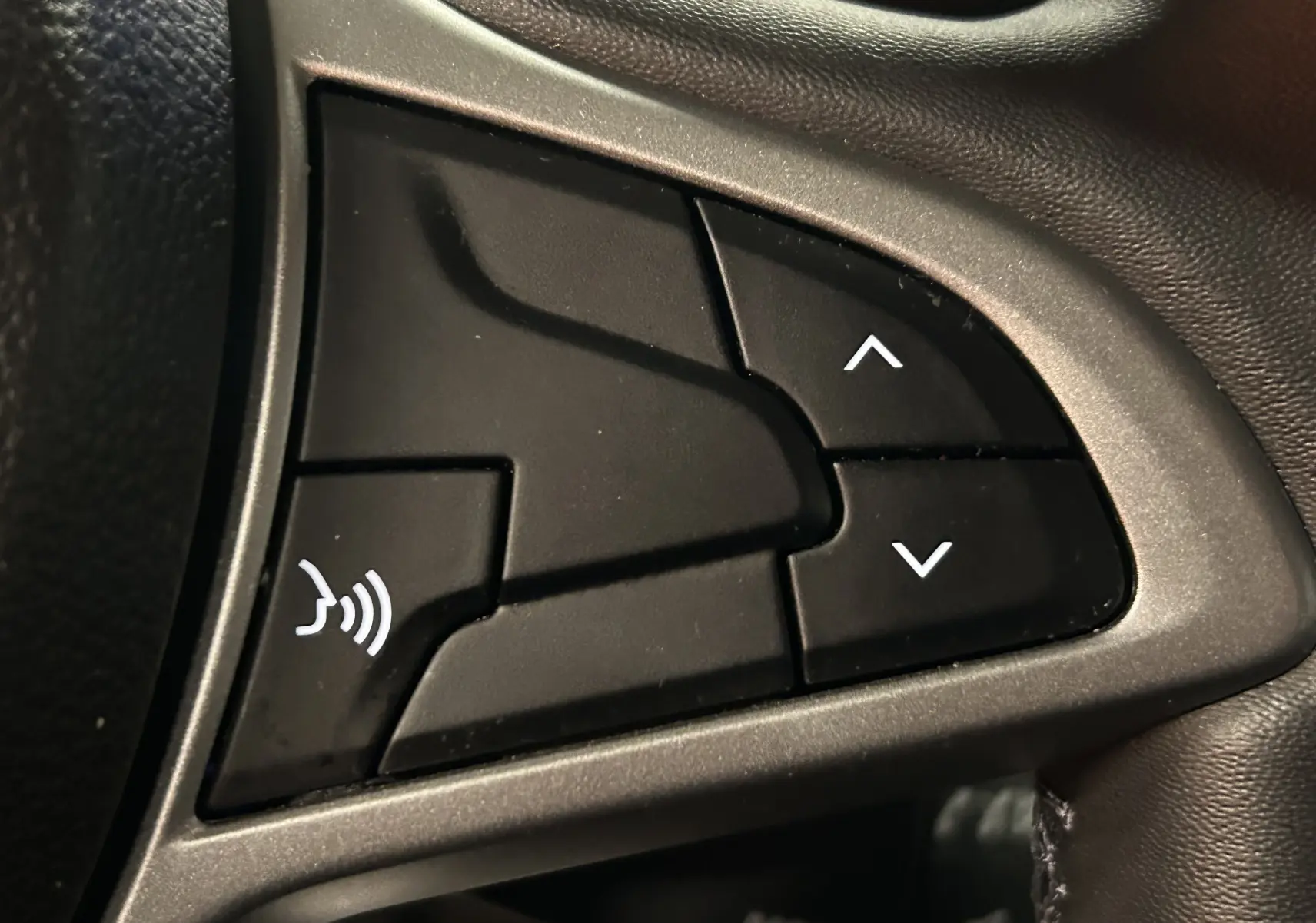 Gros plan sur les boutons de commande au volant du Dacia Duster blanc, version dCi 115 Expression 4x4, 2025.