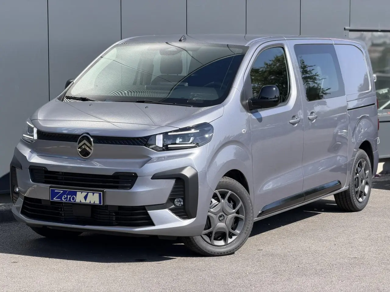 Citroën Jumpy gris Artense en 3/4 avant droit, avec jantes noires et coques de rétroviseurs noires Perla Nera.