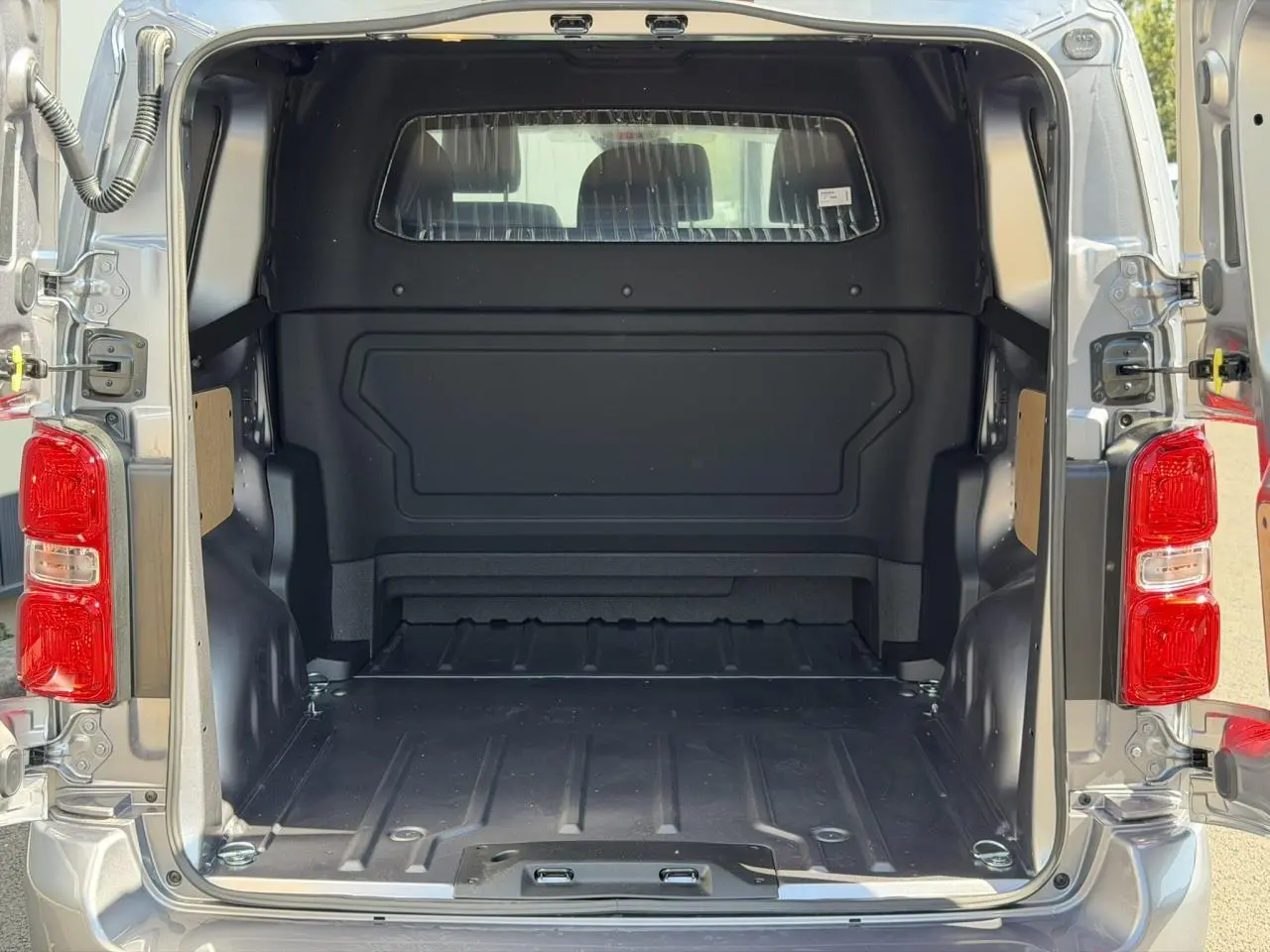 Vue arrière ouverte du Citroën Jumpy gris Artense, montrant l’espace de chargement vide et les portes battantes ouvertes.