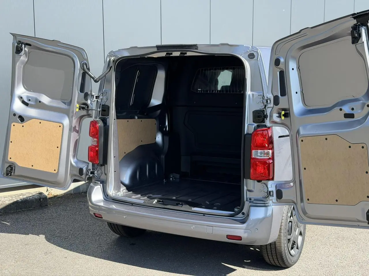 Vue arrière du Citroën Jumpy gris Artense avec portes battantes ouvertes montrant l’espace de chargement vide.