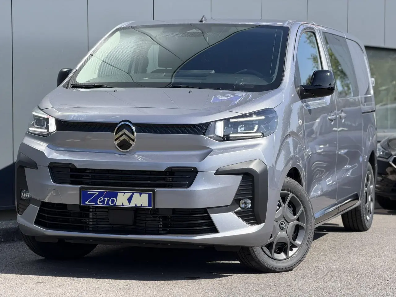 Vue 3/4 avant droit du Citroën Jumpy gris Artense avec jantes noires et calandre distinctive Pack Look.