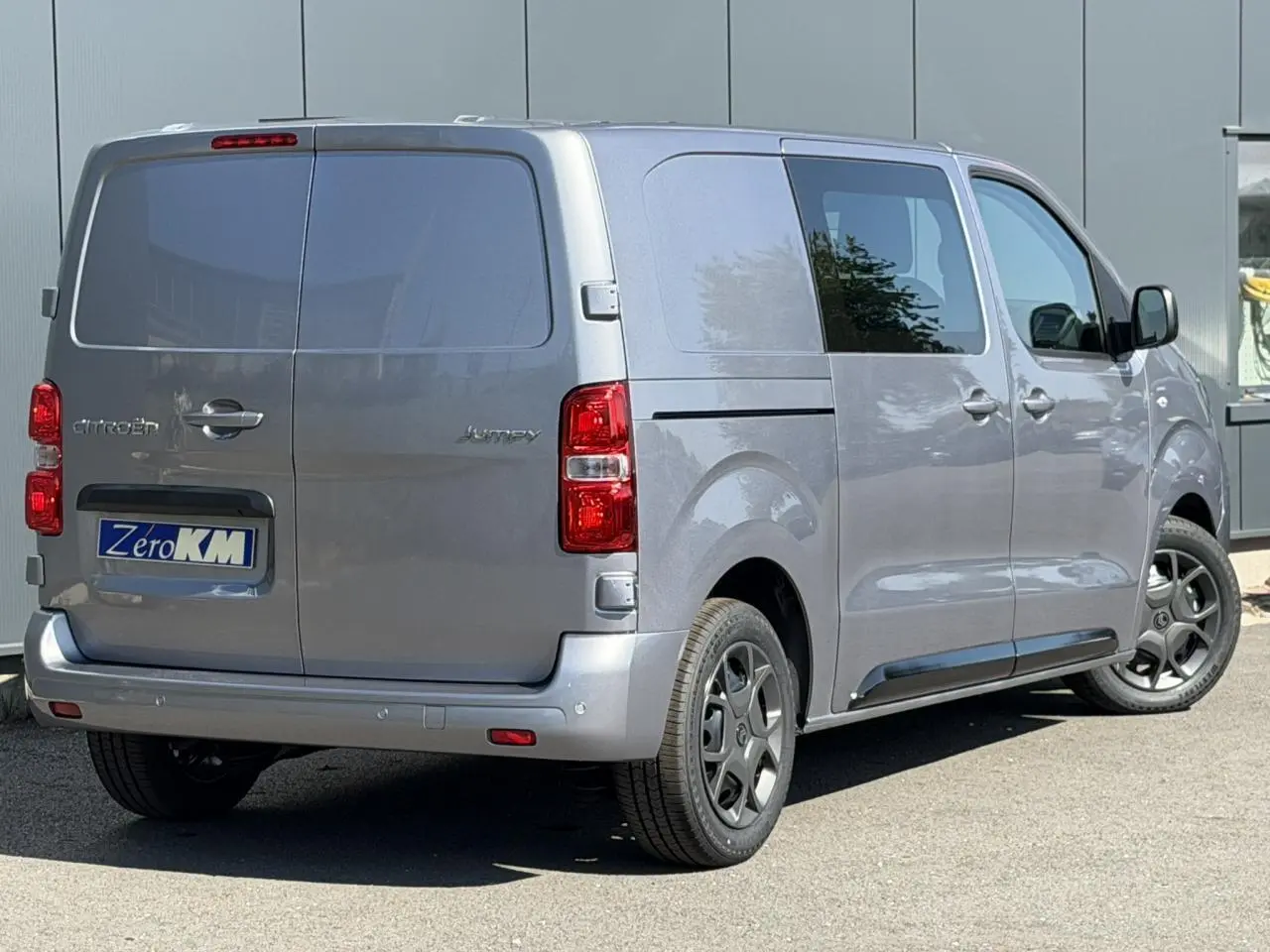 Vue 3/4 arrière droite du Citroën Jumpy gris Artense avec portes battantes arrière et jantes noires.