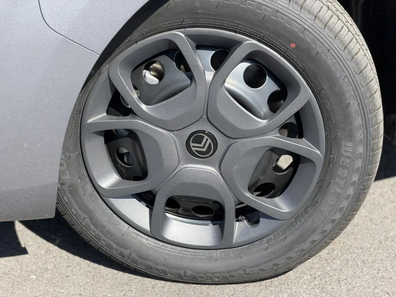 Gros plan sur la roue avant gauche avec jante tôle noire et enjoliveur du Citroën Jumpy gris Artense 2026.