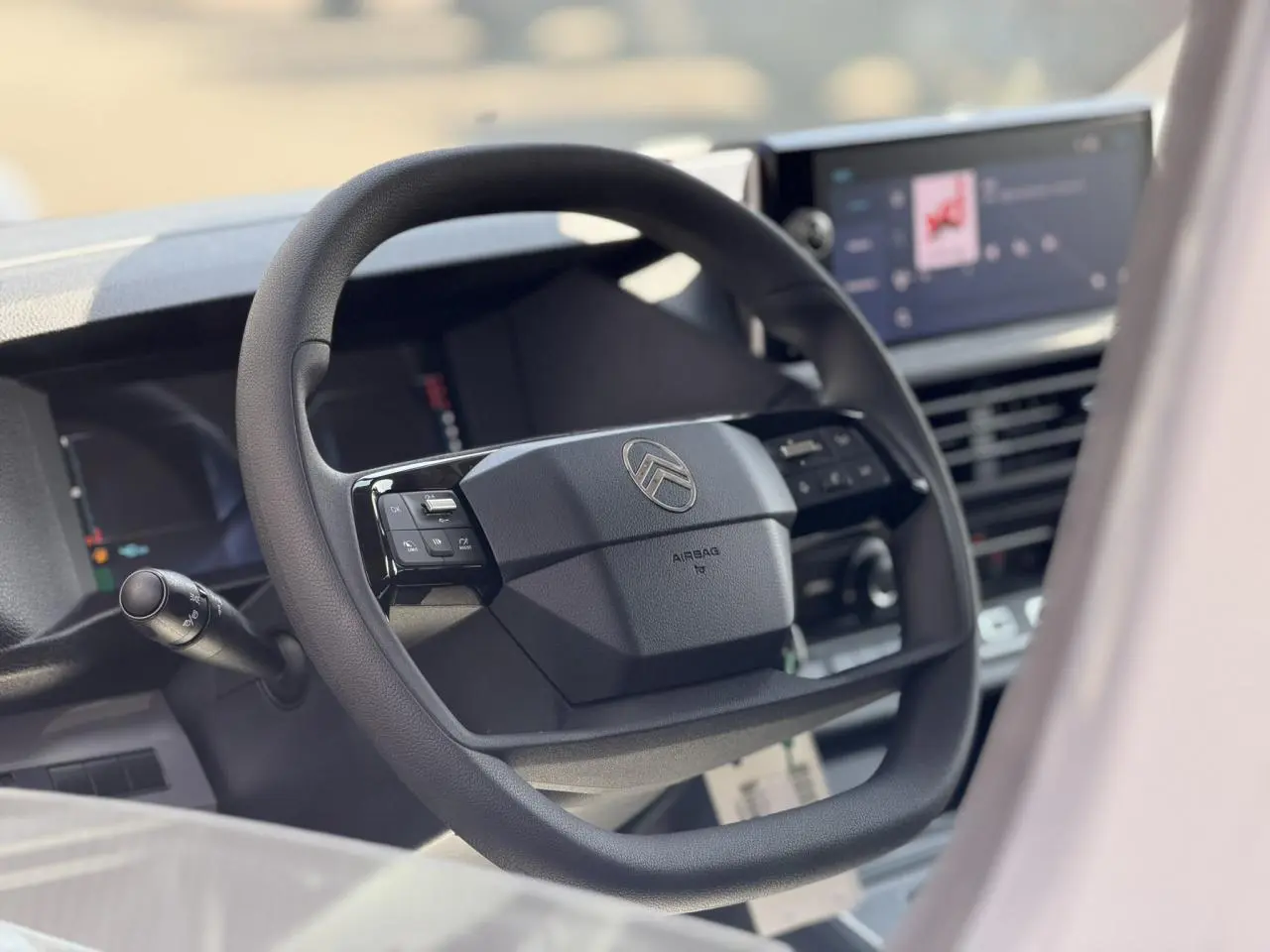 Vue rapprochée du volant Citroën Jumpy 2026 avec commandes intégrées et écran tactile en arrière-plan flou.