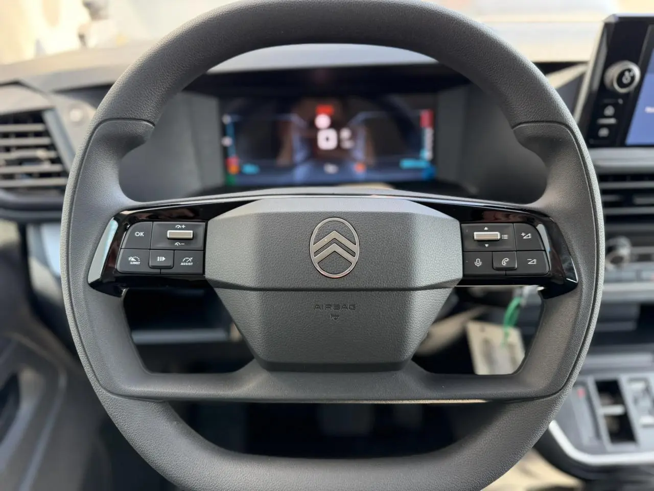 Vue rapprochée du volant noir de la Citroën Jumpy 2026 avec commandes intégrées et logo central argenté.