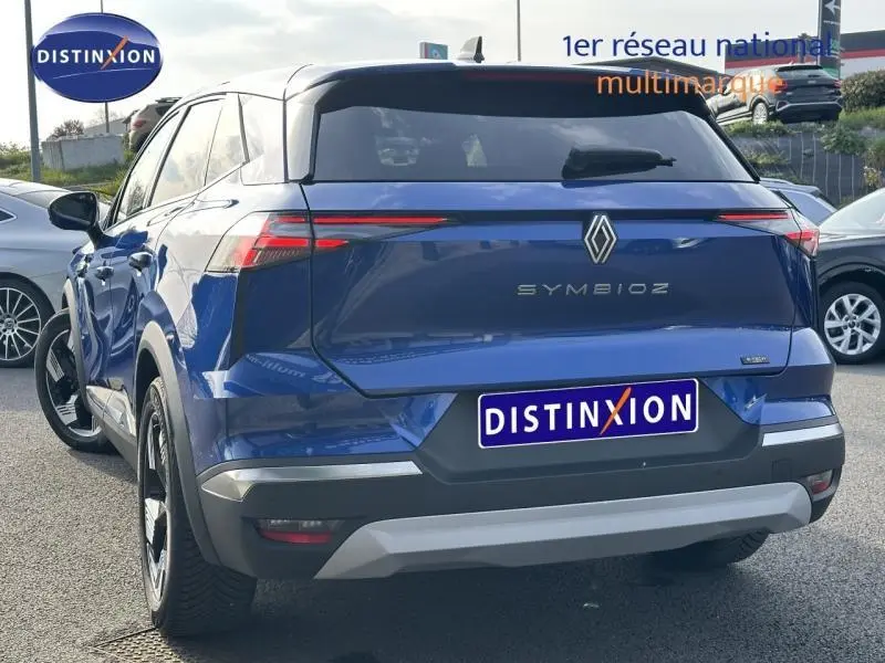 Vue 3/4 arrière d'un Renault Symbioz bleu, mettant en valeur ses feux arrière LED fins et son design moderne.