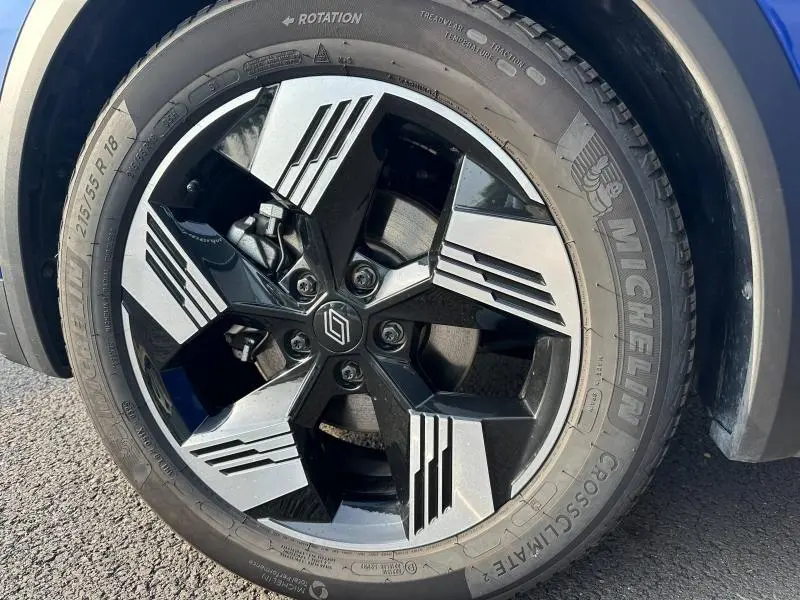 Gros plan sur la jante alu bicolore noire et argentée du Renault Symbioz 2025, avec pneu Michelin visible en extérieur.