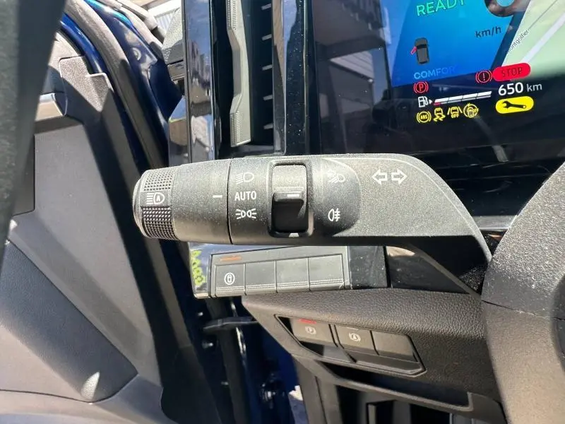 Gros plan sur la commande des feux et clignotants côté gauche du tableau de bord d’un Renault Austral bleu Iron 2025.