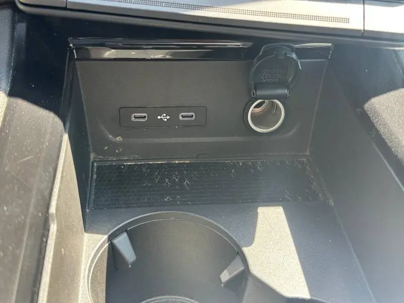 Vue rapprochée de la console centrale noire du Renault Austral 2025 avec prises USB-C et prise 12V ouverte.