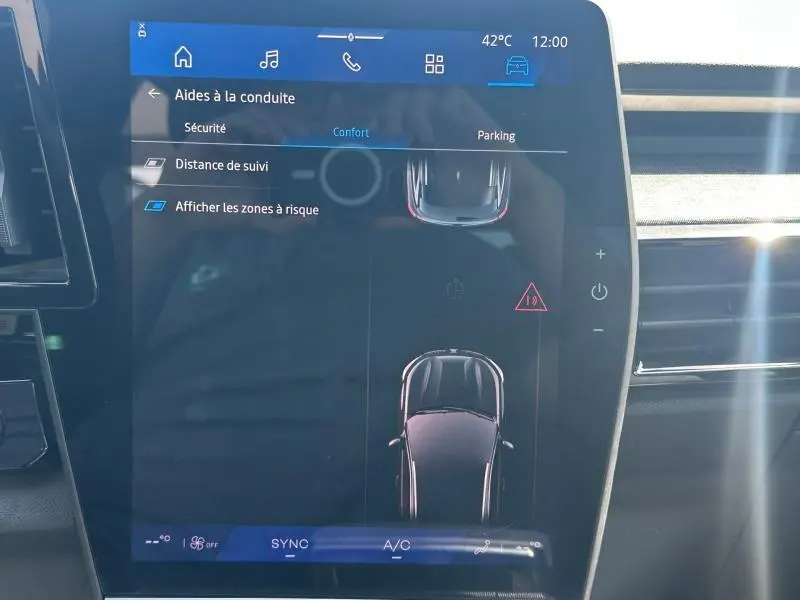 Écran tactile intérieur du Renault Austral 2025 affichant les aides à la conduite et la vue top-down du véhicule.