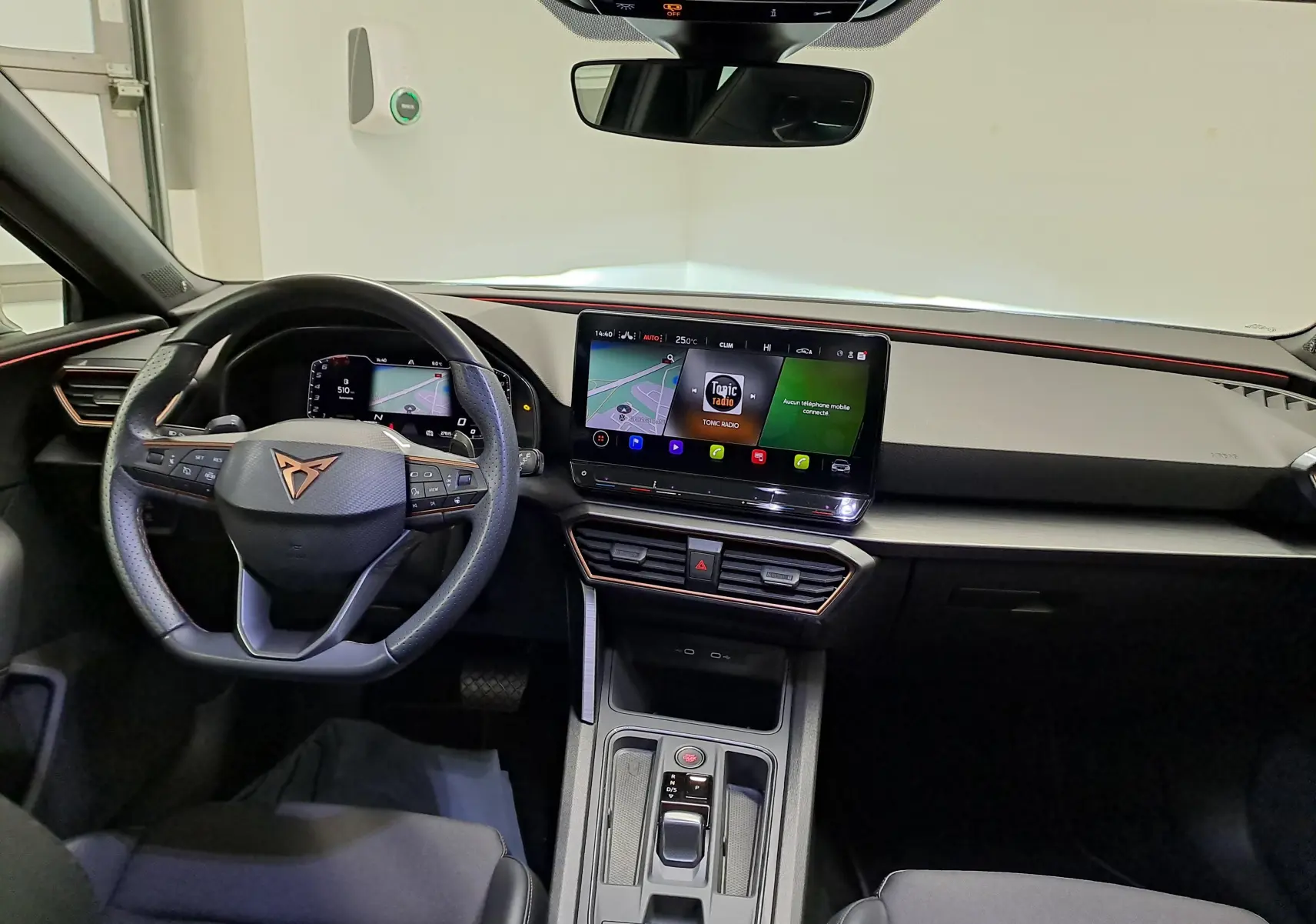 Vue intérieure avant de la CUPRA Leon 1.5 TSI 2023 avec tableau de bord numérique et écran tactile central.