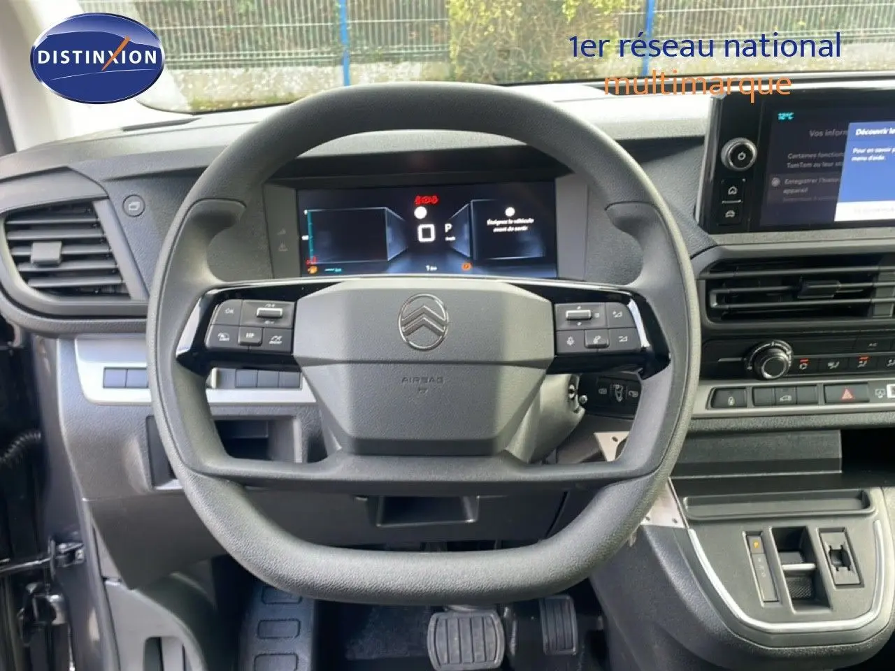 Vue rapprochée du volant multifonction et du tableau de bord numérique d'un Citroën Jumpy gris titane.