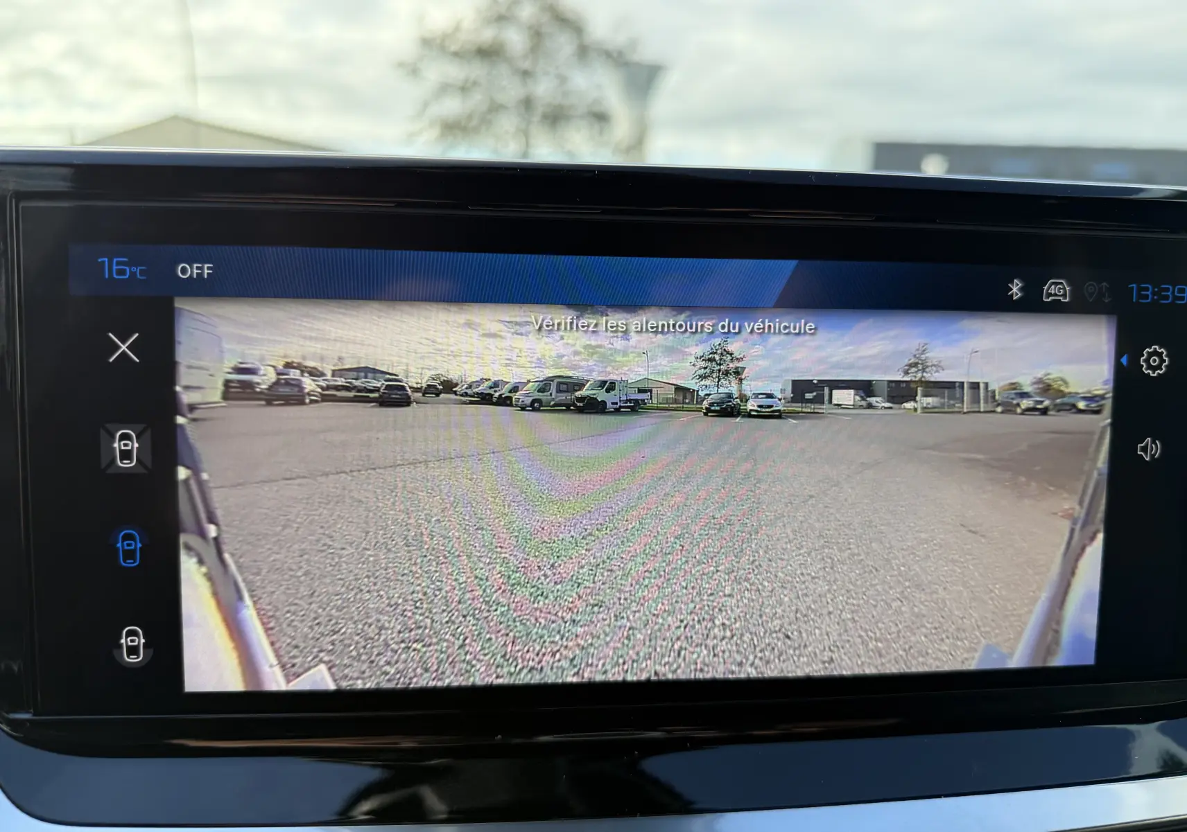 Vue de la caméra de recul du Peugeot 2008 gris selenium au toit noir, affichée sur l'écran intérieur.