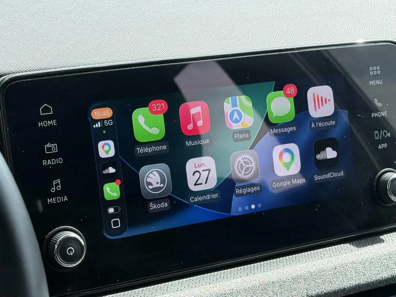 Écran tactile central 8,25" du Skoda Scala TSI 116 gris graphite, affichant interface Apple CarPlay.