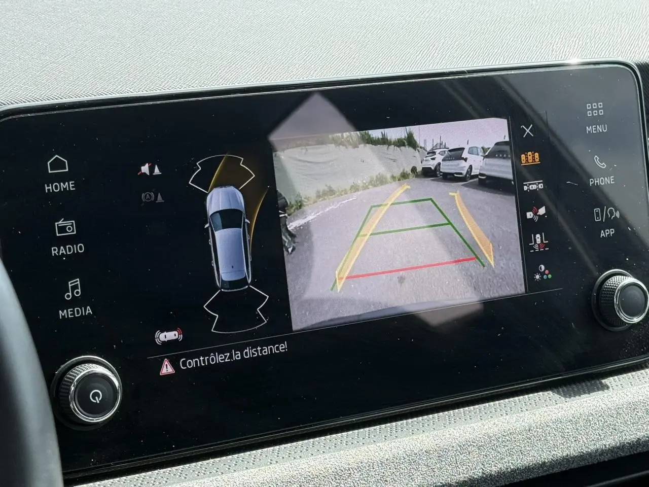 Écran tactile de la Skoda Scala TSI 116 gris graphite montrant la caméra de recul avec guidage dynamique.