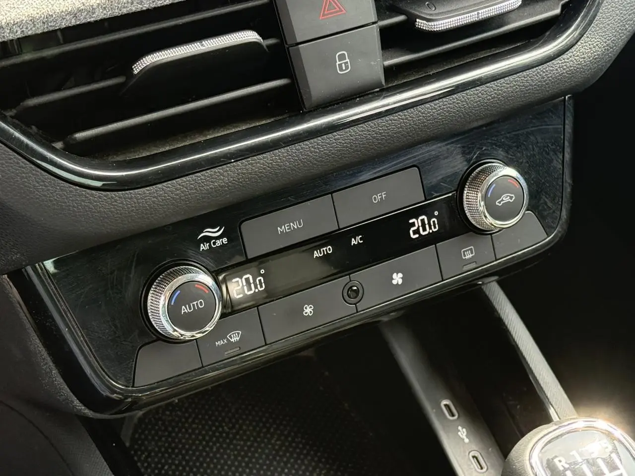 Gros plan sur la console centrale noire du Skoda Scala TSI 116, montrant la climatisation automatique bi-zone à 20°C.