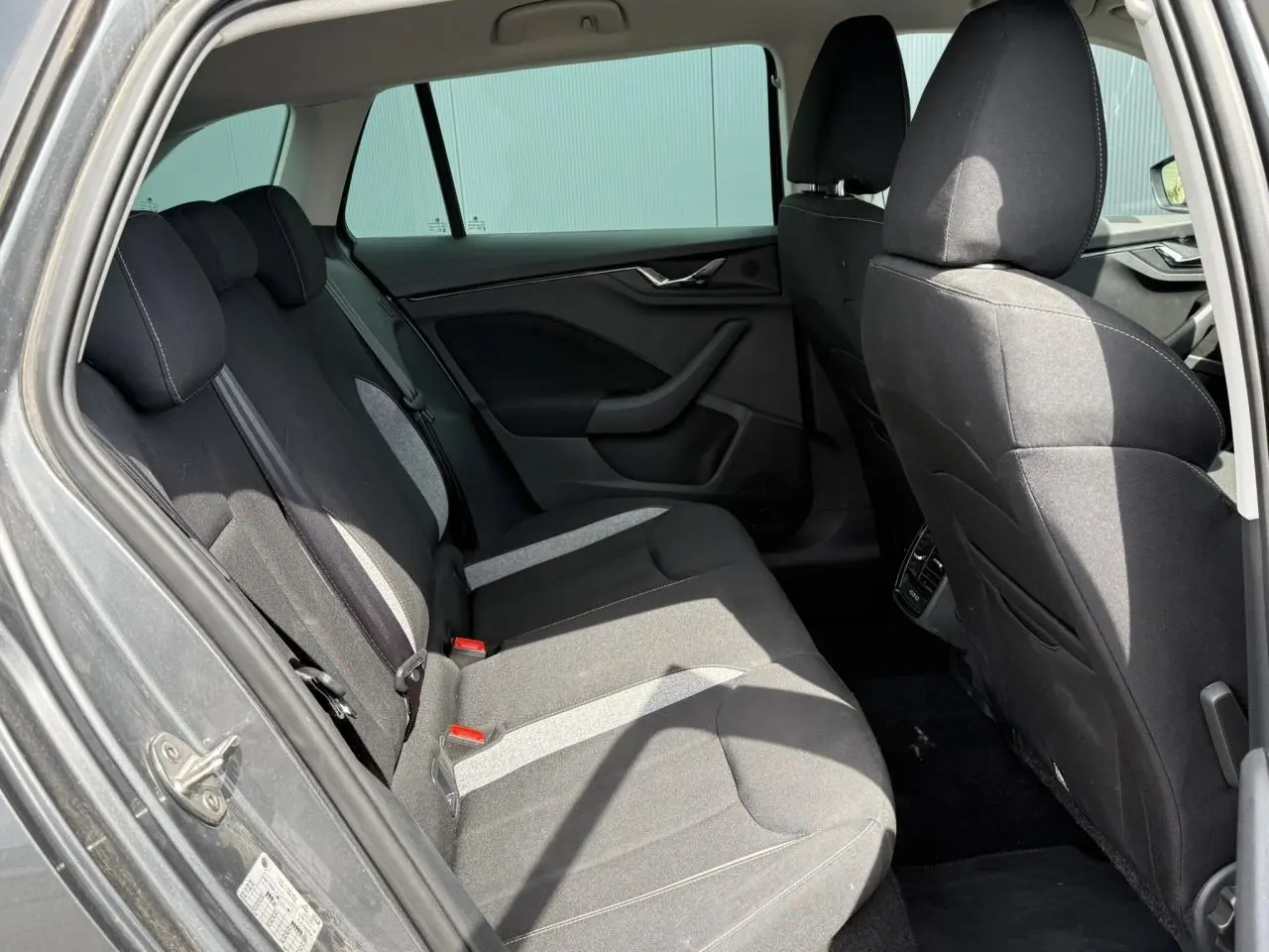 Vue intérieure côté gauche sur la banquette arrière noire et grise du Skoda Scala TSI 116 Sélection 2025 gris graphite.