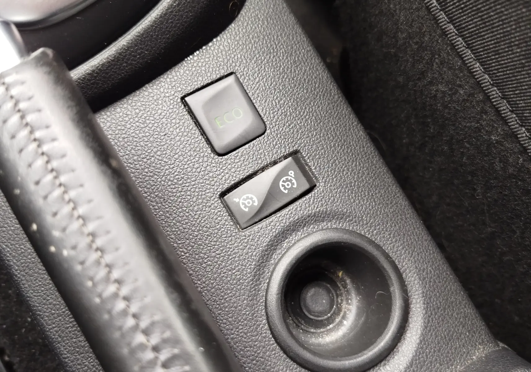 Gros plan sur les boutons de commande ECO et régulateur de vitesse dans la console centrale d’un Renault Captur bleu marine.