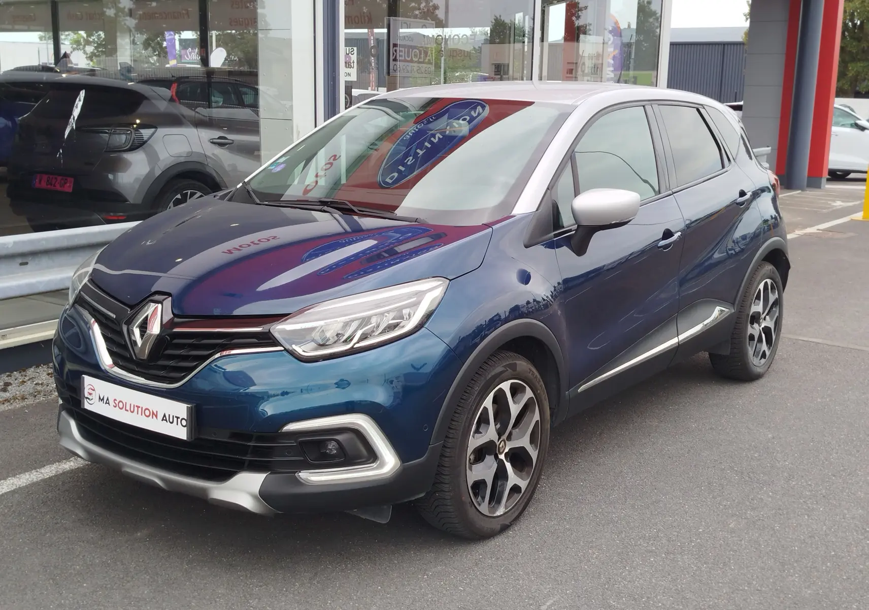 Renault Captur 2018 bleu marine fumé avec toit gris platine, vue 3/4 avant droit, jantes alliage bicolores.