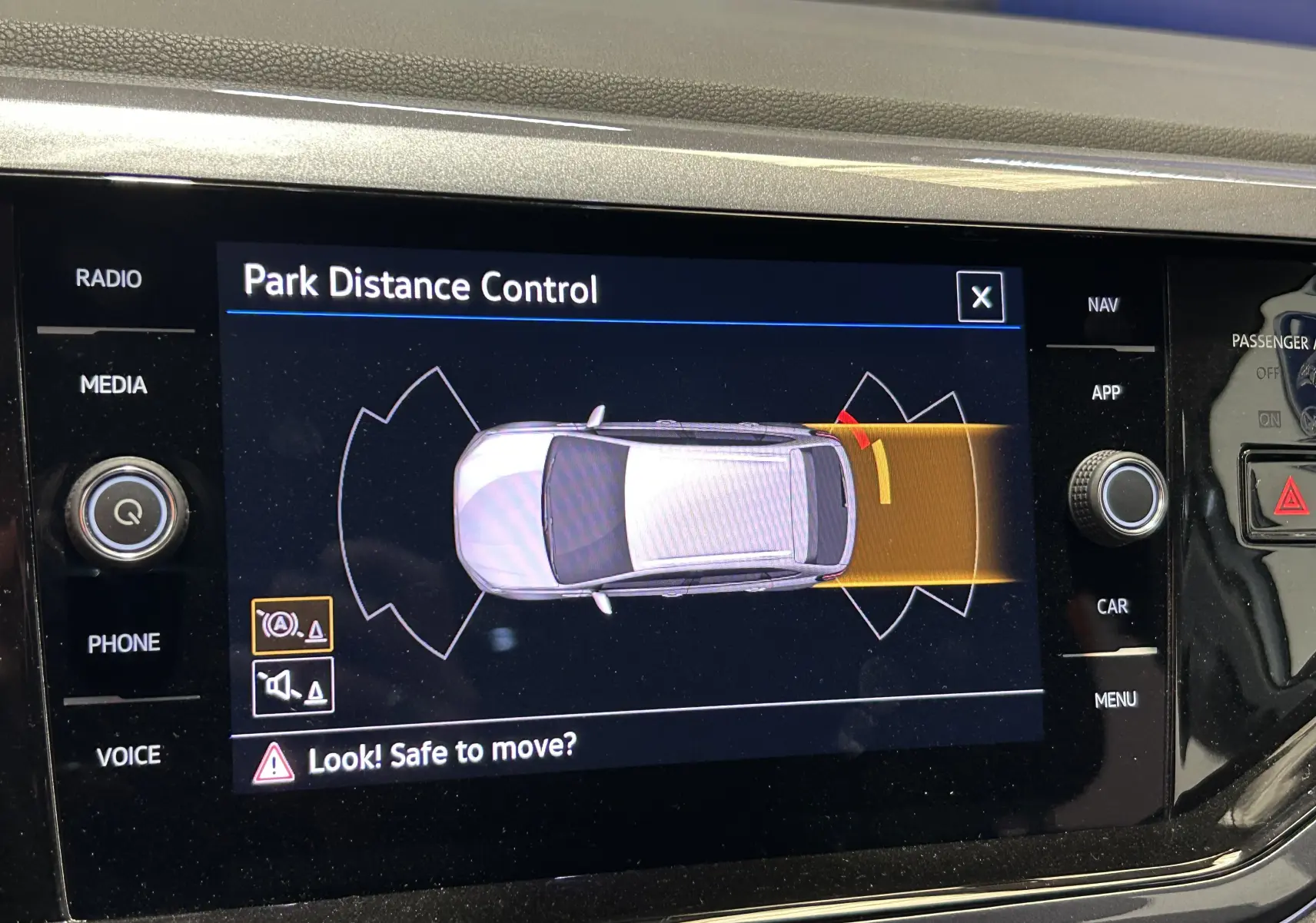 Écran intérieur du Volkswagen Taigo blanc montrant l'alerte de distance de stationnement arrière en mode automatique.