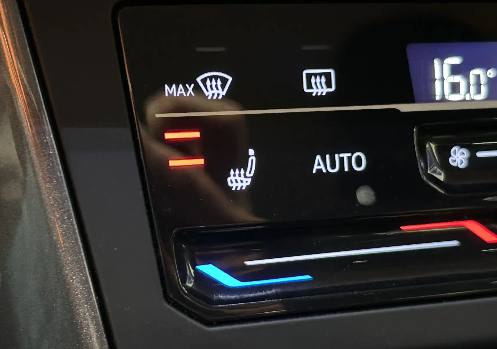 Gros plan sur les commandes de climatisation automatique et siège chauffant du Volkswagen Taigo blanc 2022.