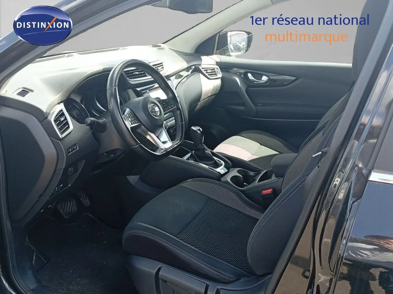 Intérieur du Nissan Qashqai 2018 noir métal, vue côté conducteur montrant le tableau de bord et les sièges avant.