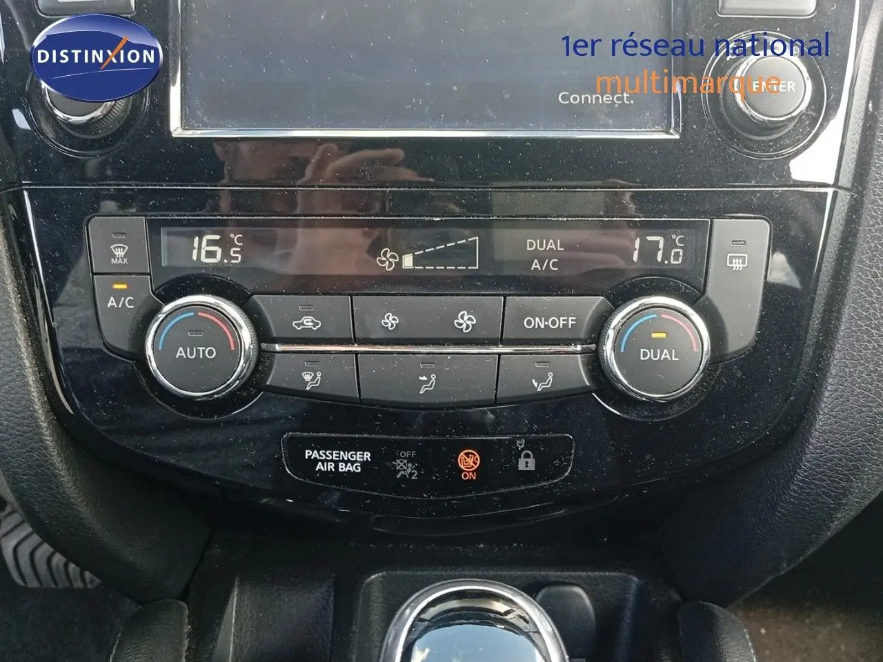 Tableau de bord du Nissan Qashqai noir métal 2018, zoom sur la console de climatisation automatique avec affichage digital.