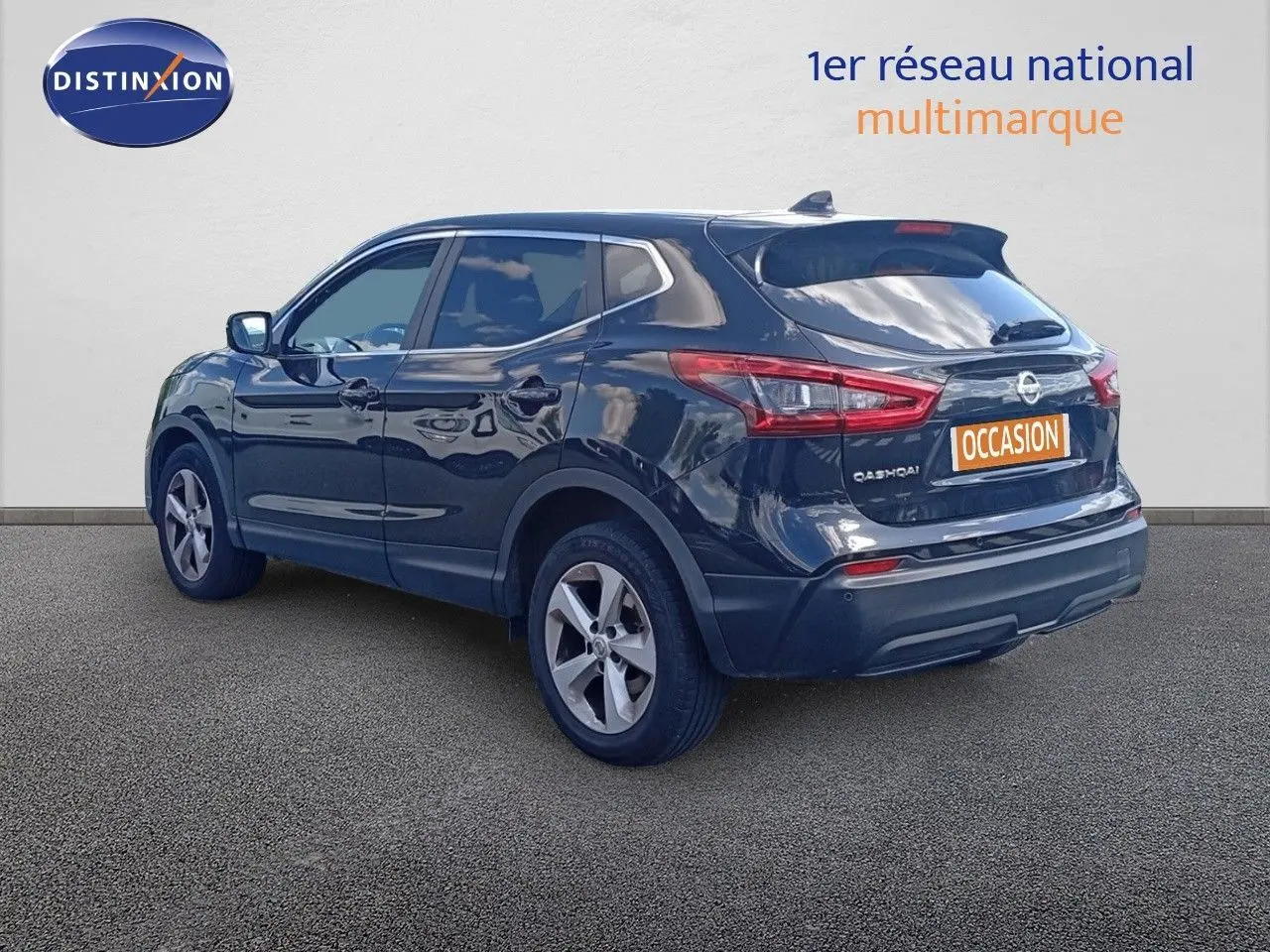 Nissan Qashqai noir métal en vue 3/4 arrière droit, avec jantes alliage et logo "Occasion" sur le coffre.