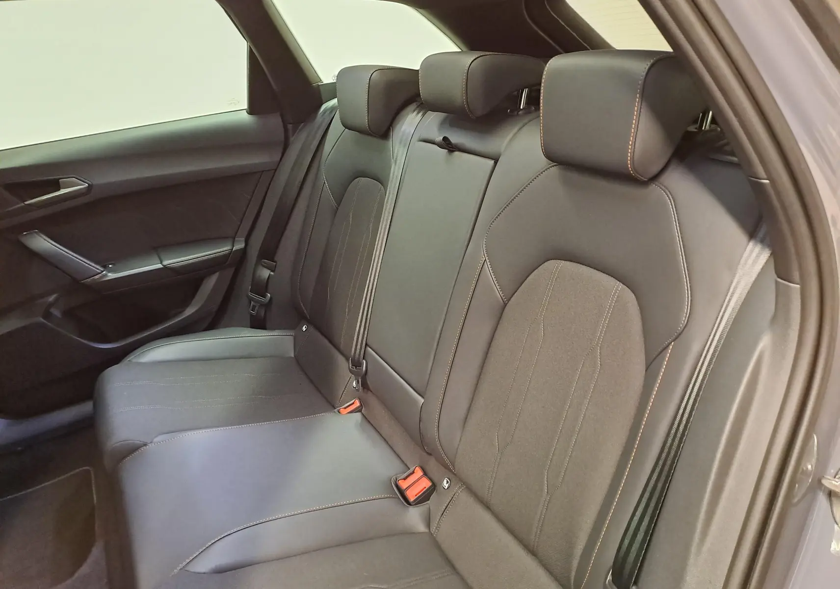 Vue intérieure arrière côté droit des sièges arrière noirs avec surpiqûres cuivrées du CUPRA LEON ST 2025 gris Graphène.