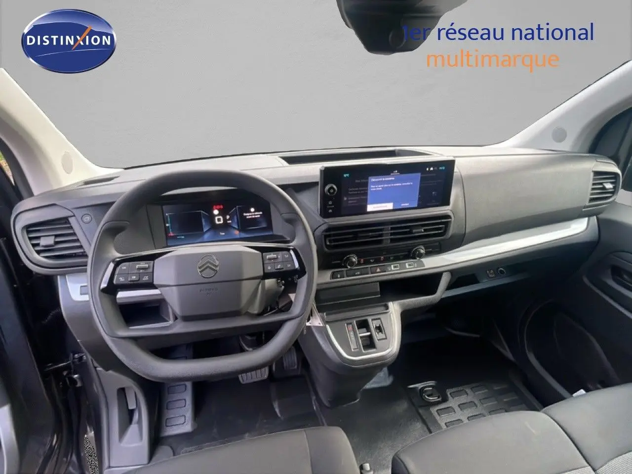 Vue intérieure avant du Citroën Jumpy gris titane, tableau de bord moderne avec écran tactile et volant multifonction.