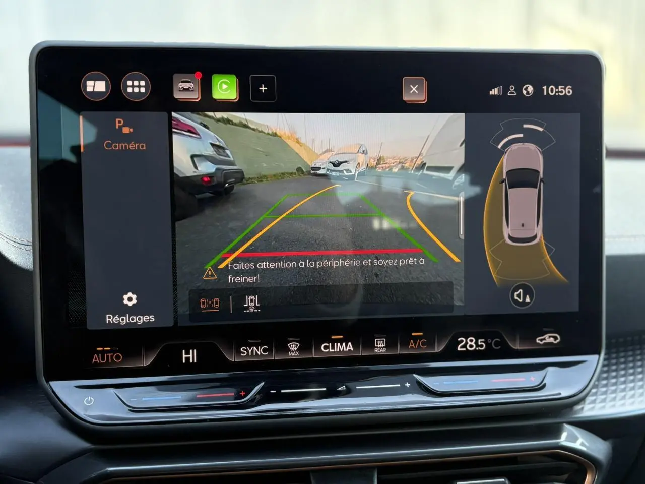 Écran tactile intérieur de la CUPRA Leon blanc montrant la caméra de recul avec aides au stationnement activées.