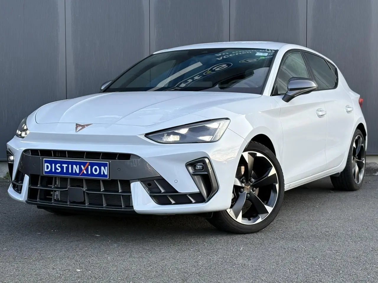 Vue 3/4 avant droite d'une CUPRA Leon blanche Neige avec jantes alliage 18'' et signature lumineuse Tri-LED.