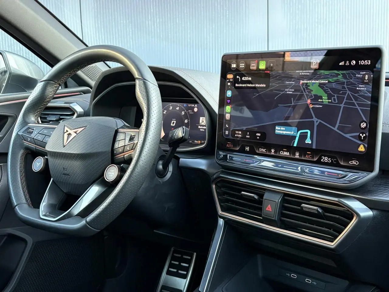 Vue intérieure centrée sur le volant cuir perforé et l'écran tactile HD 12,9'' du tableau de bord de la CUPRA Leon 2025.