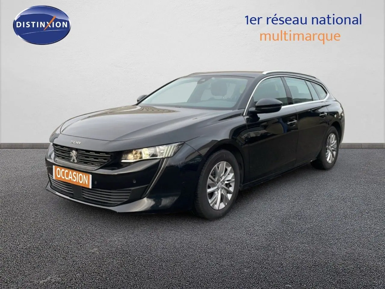 Peugeot 508 SW noire vue en 3/4 avant droit, avec phares allumés et jantes alliage argentées.