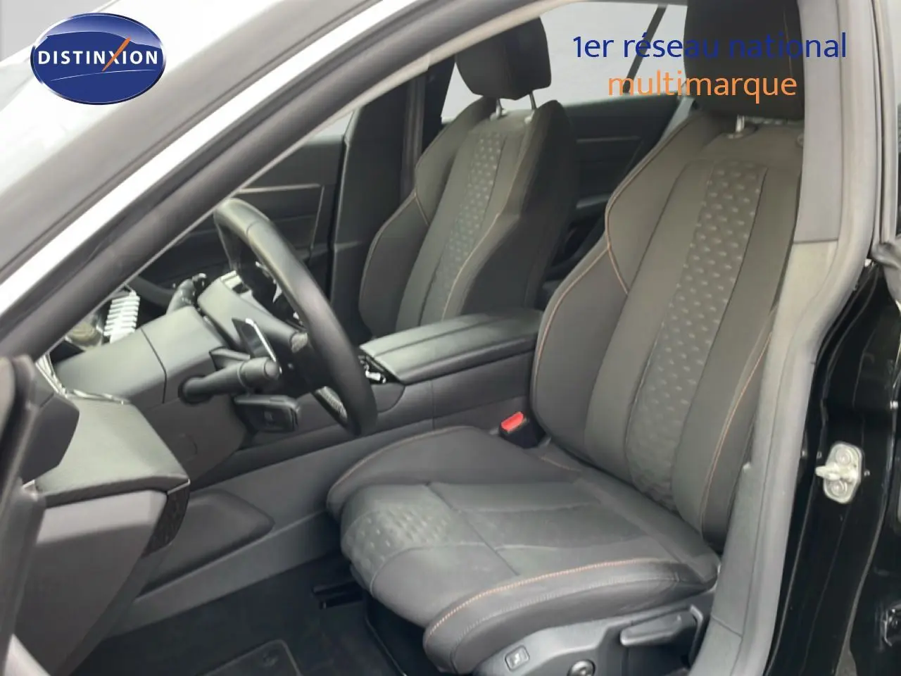 Vue intérieure côté conducteur du Peugeot 508 SW noir Perla Nera, mettant en valeur les sièges en tissu noir avec surpiqûres contrastées.