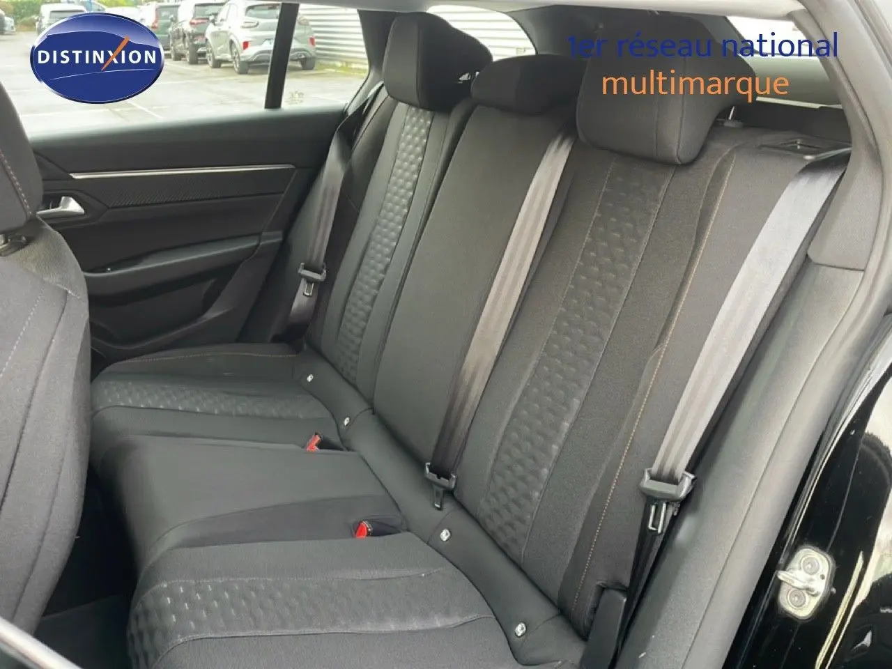 Vue intérieure sur les sièges arrière en tissu noir de la Peugeot 508 SW 2021, porte ouverte côté droit.