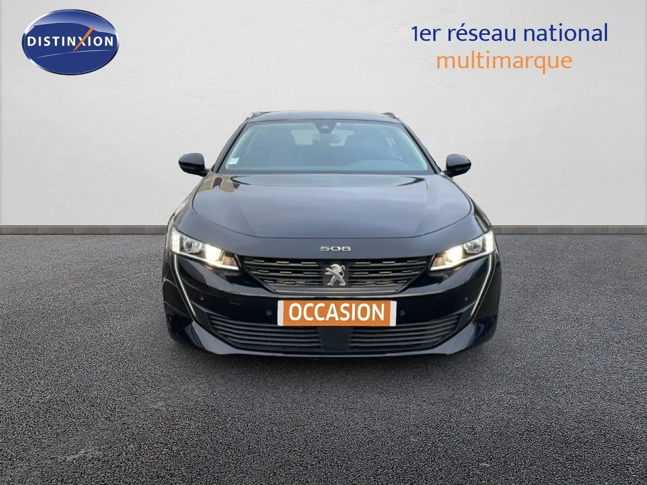 Vue avant d'une Peugeot 508 SW noire Perla Nera Metal avec phares allumés et plaque "OCCASION" visible.