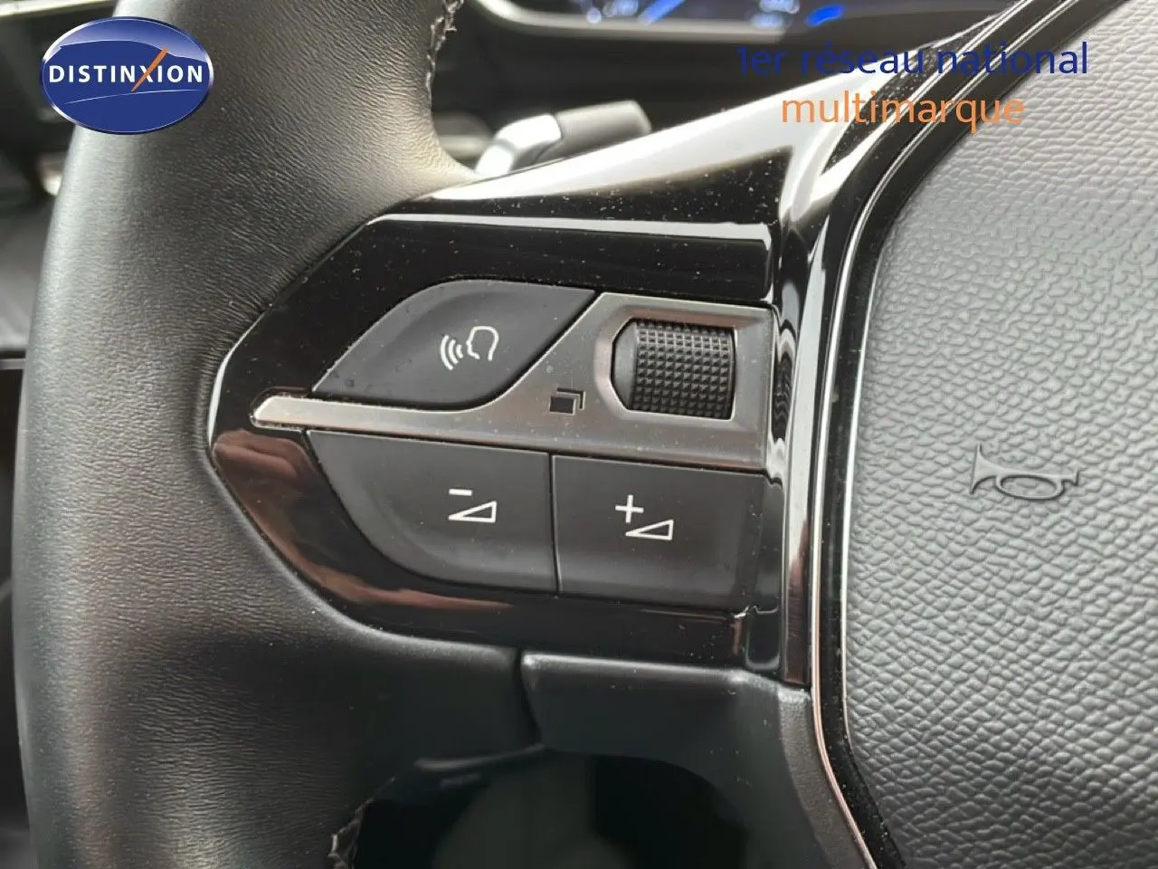 Gros plan sur les commandes gauche du volant cuir noir du Peugeot 508 SW noir Perla Nera 2021, avec boutons de volume et appel.