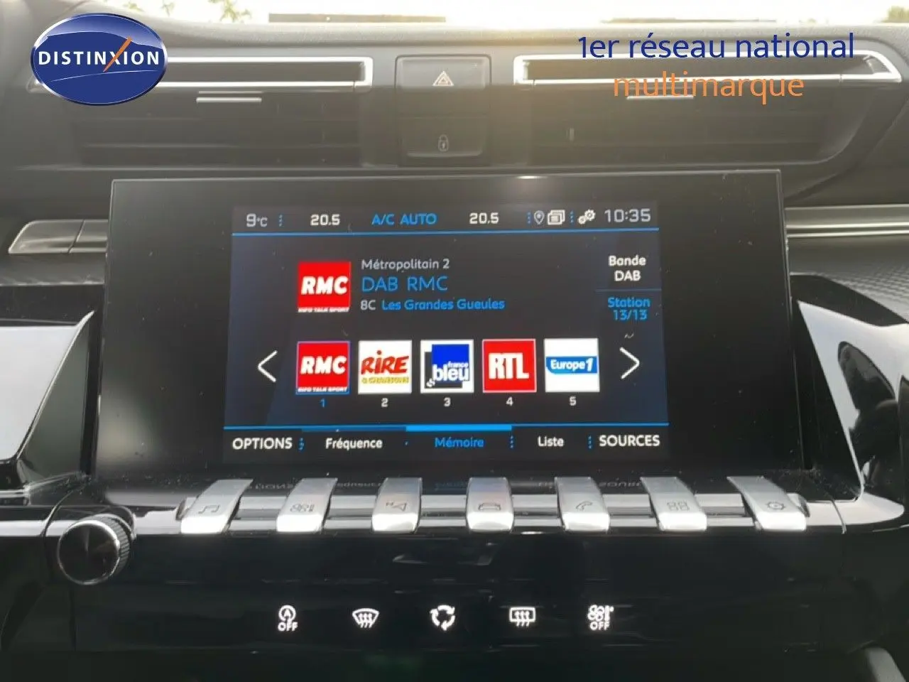 Vue rapprochée de l’écran tactile central de la Peugeot 508 SW 2021, affichant les stations radio avec finition noire brillante.
