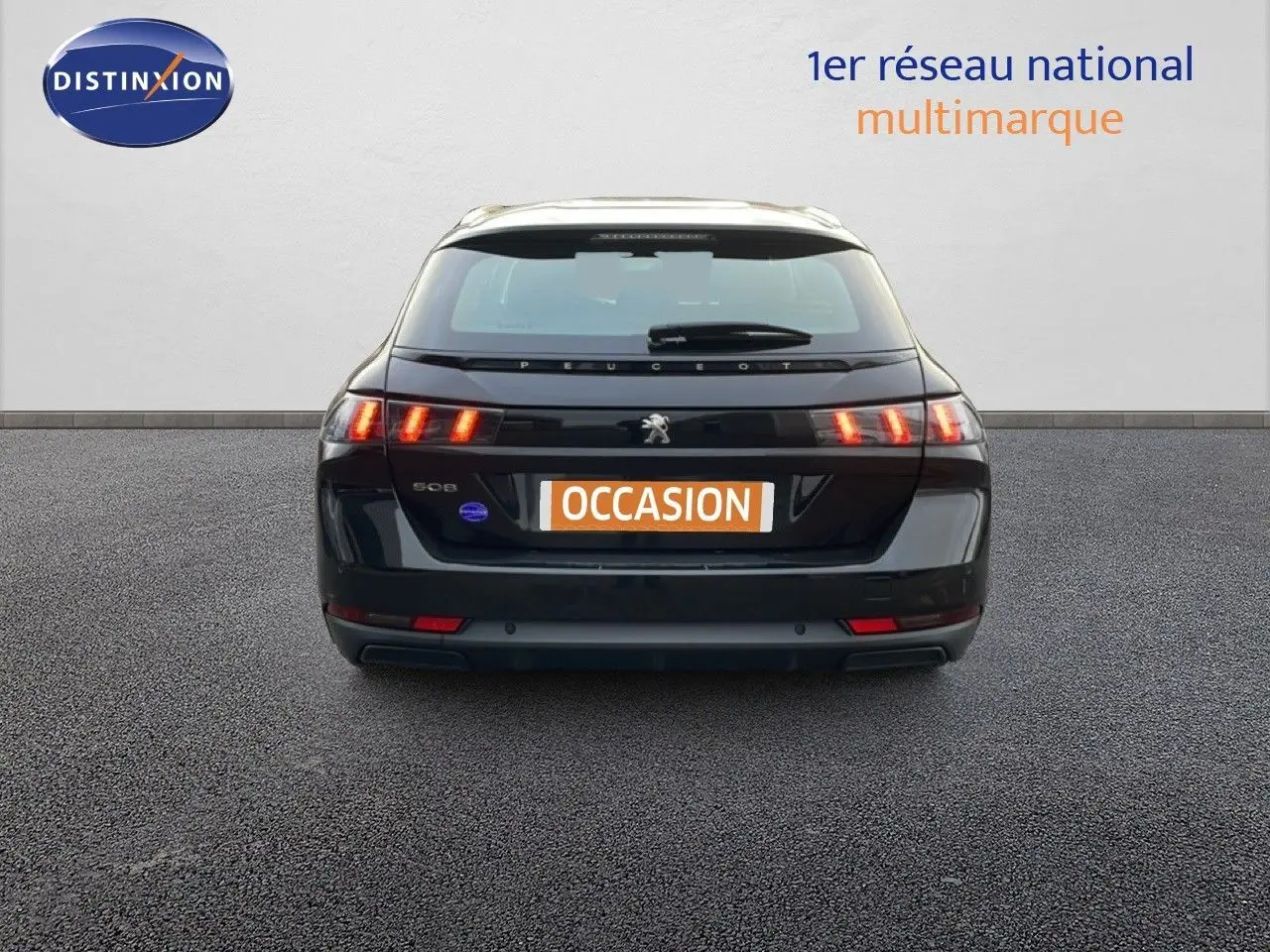 Vue arrière d'une Peugeot 508 SW noire Perla Nera Metal avec feux arrière allumés sur fond neutre.