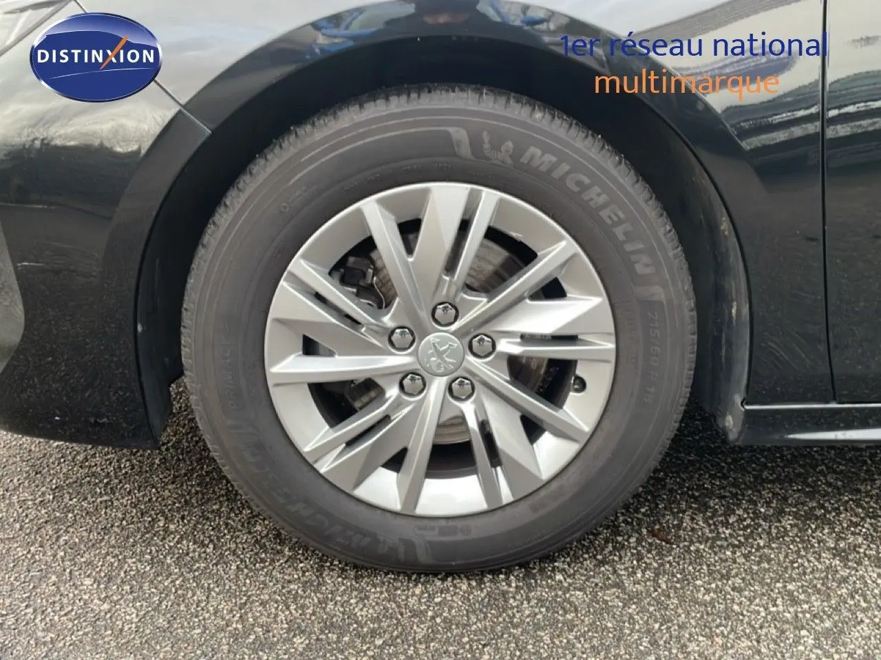 Gros plan sur la roue avant gauche de la Peugeot 508 SW noire, mettant en valeur la jante alliage et le pneu Michelin.
